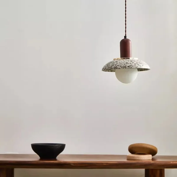 Single ceramic pendant suspended above a wooden tabletop